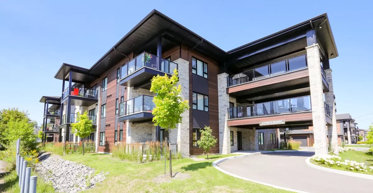 Entrée principale avec marquise architecturale en bois et pierre – immeuble Ratelle & Ratelle St-Charles-Borromée