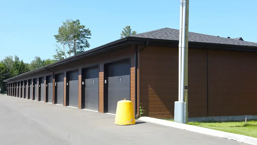 Bâtiment de 24 garages avec revêtement brun et portes grises – projet Ratelle & Ratelle St-Charles-Borromée par BGC