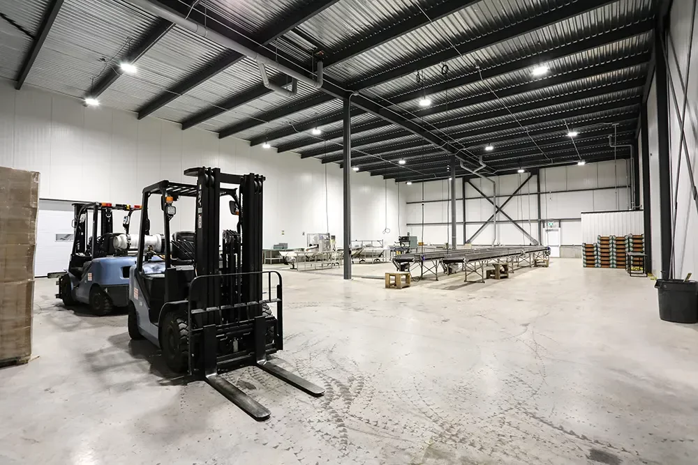 Intérieur de l'entrepôt réfrigéré en structure d'acier avec chariots élévateurs – Jardins Brunelle Saint-Thomas