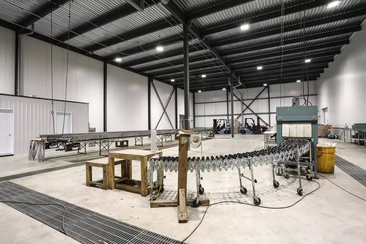 Aire de production avec convoyeurs et structure d'acier apparente – entrepôt réfrigéré Jardins Brunelle