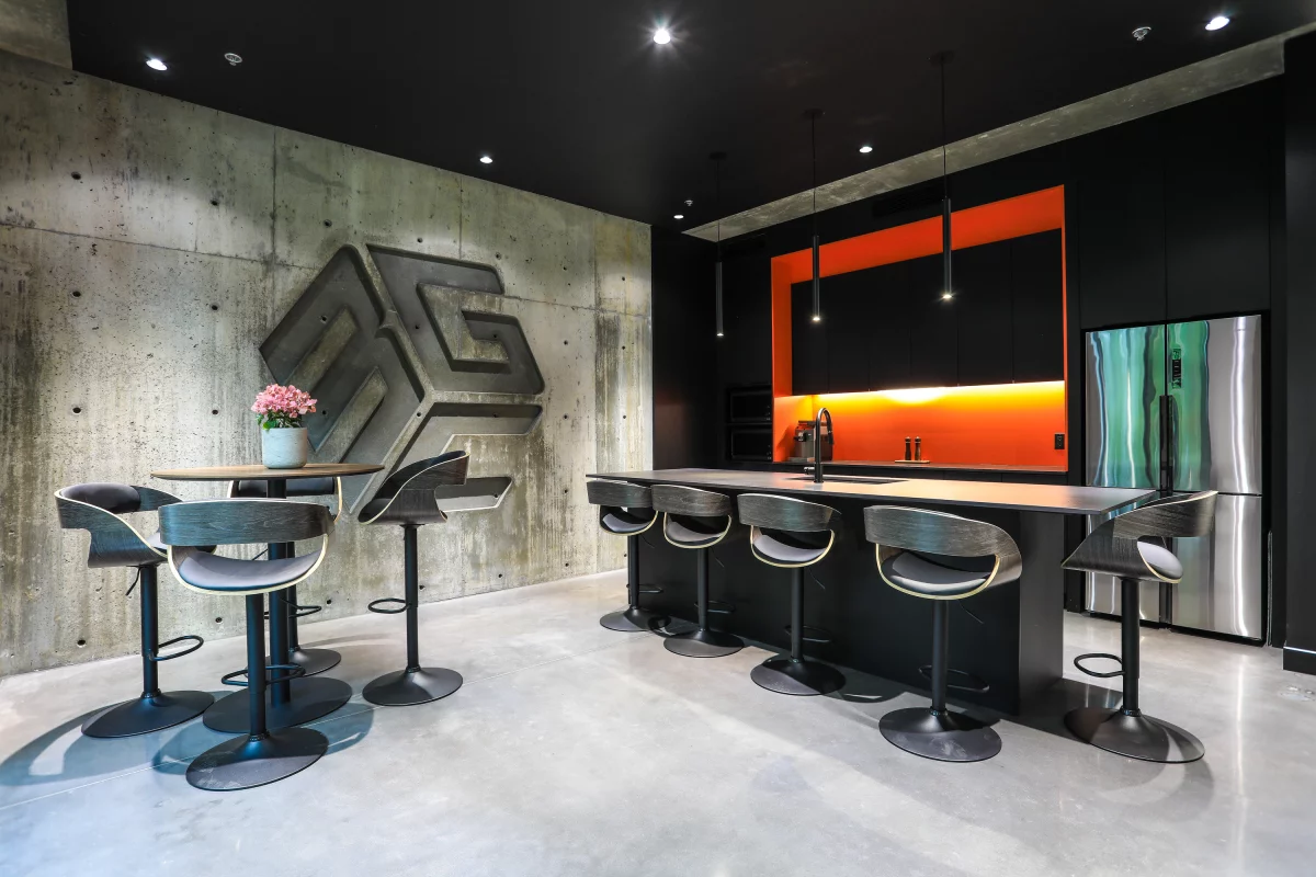 Espace de travail avec plafond de béton, grandes fenêtres et logo BGC métallique