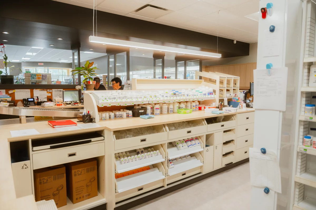 Comptoir de préparation avec tiroirs et éclairage suspendu – aménagement pharmacie