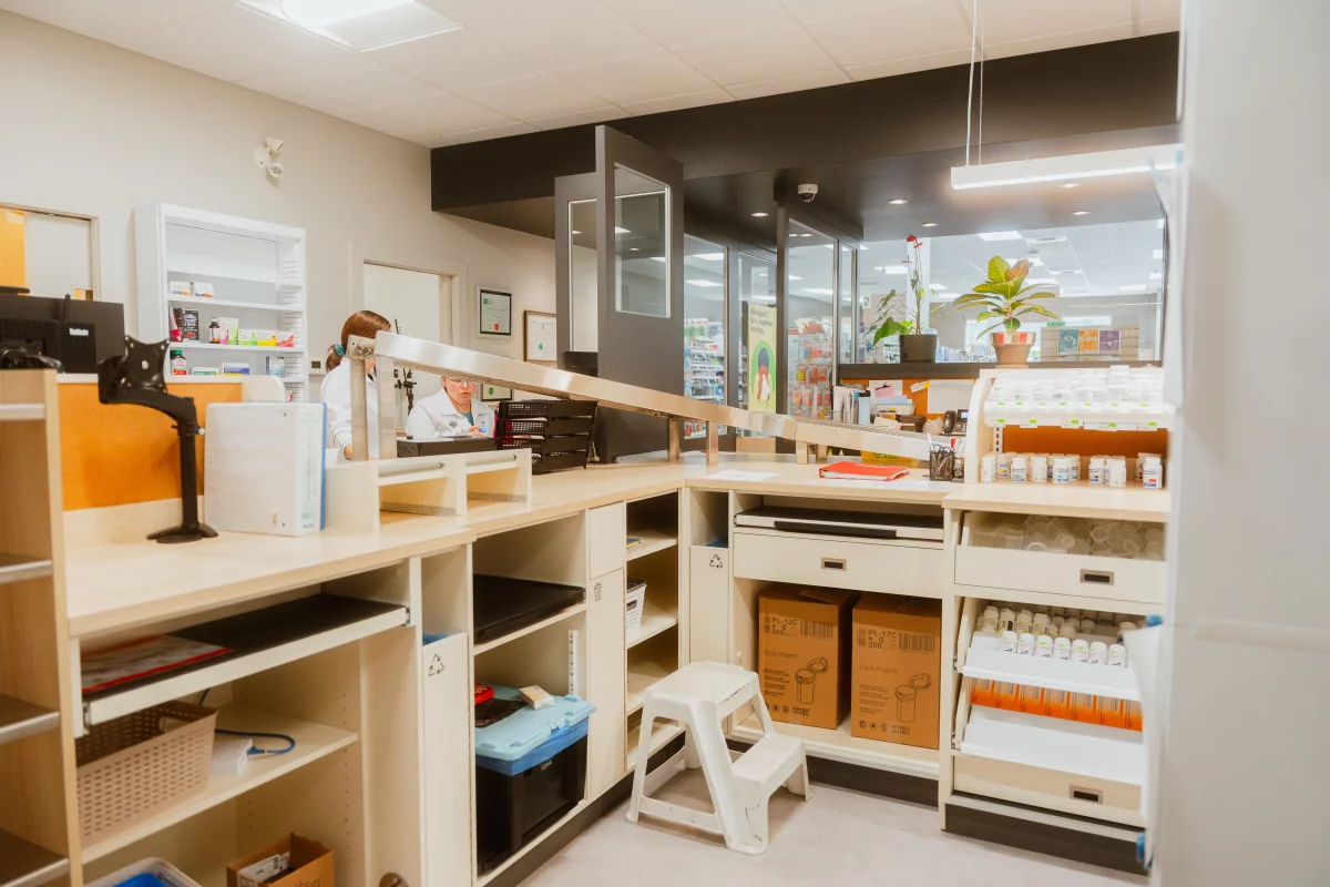 Comptoir de préparation avec tiroirs et éclairage suspendu – aménagement pharmacie