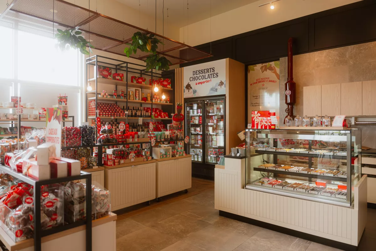 Section boutique avec étalages de produits et comptoir vitré – aménagement commercial BGC