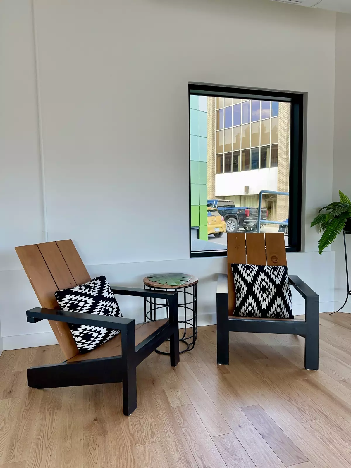 Coin détente avec fauteuils Adirondack en bois et coussins graphiques noir et blanc