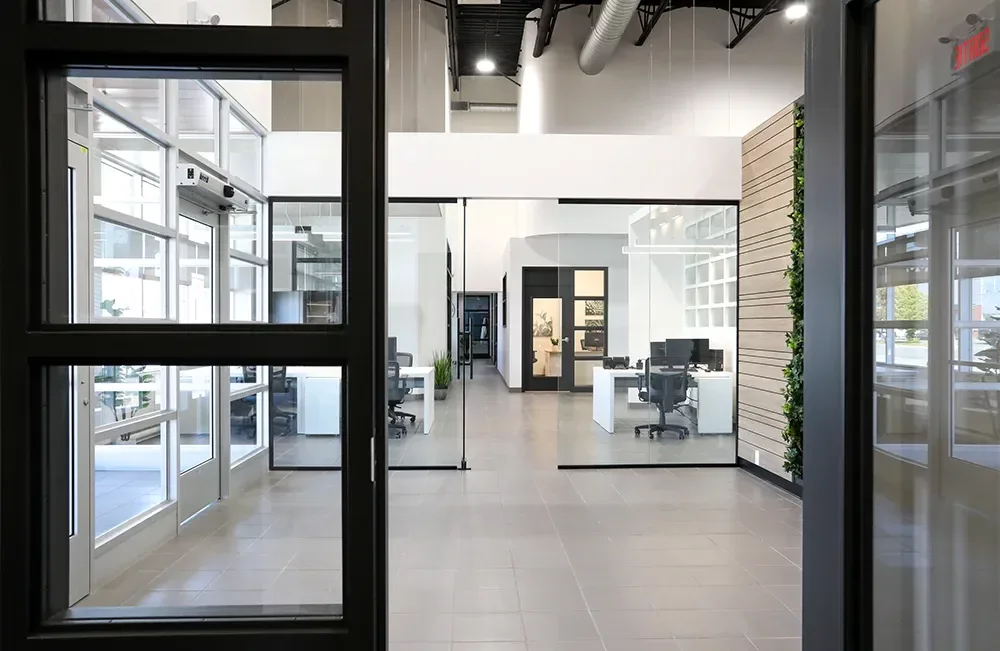 Hall d'entrée moderne avec portes vitrées, mur végétal et comptoir d'accueil – Équipements Industriel Joliette