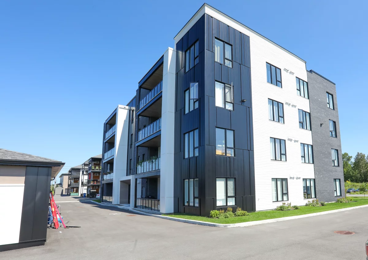 Vue latérale de l'immeuble Munger avec stationnement – St-Charles-Borromée