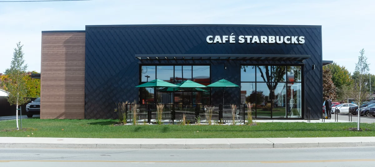 Bâtiment Starbucks avec façade noire et grandes vitrines sur rue Visitation à Joliette