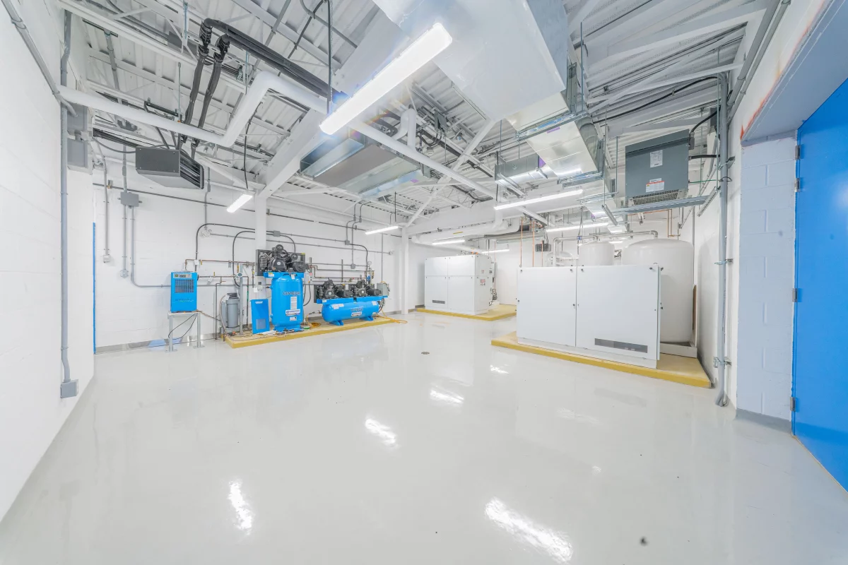 Salle des compresseurs avec équipements bleus et unités de traitement – construction institutionnelle