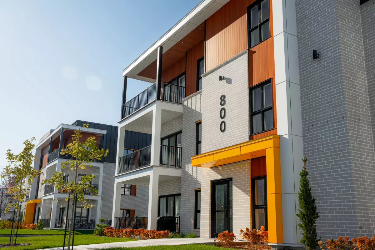 Immeuble multi-résidentiel 800 avec façade blanche, accents orange et bois – construction BGC Lanaudière