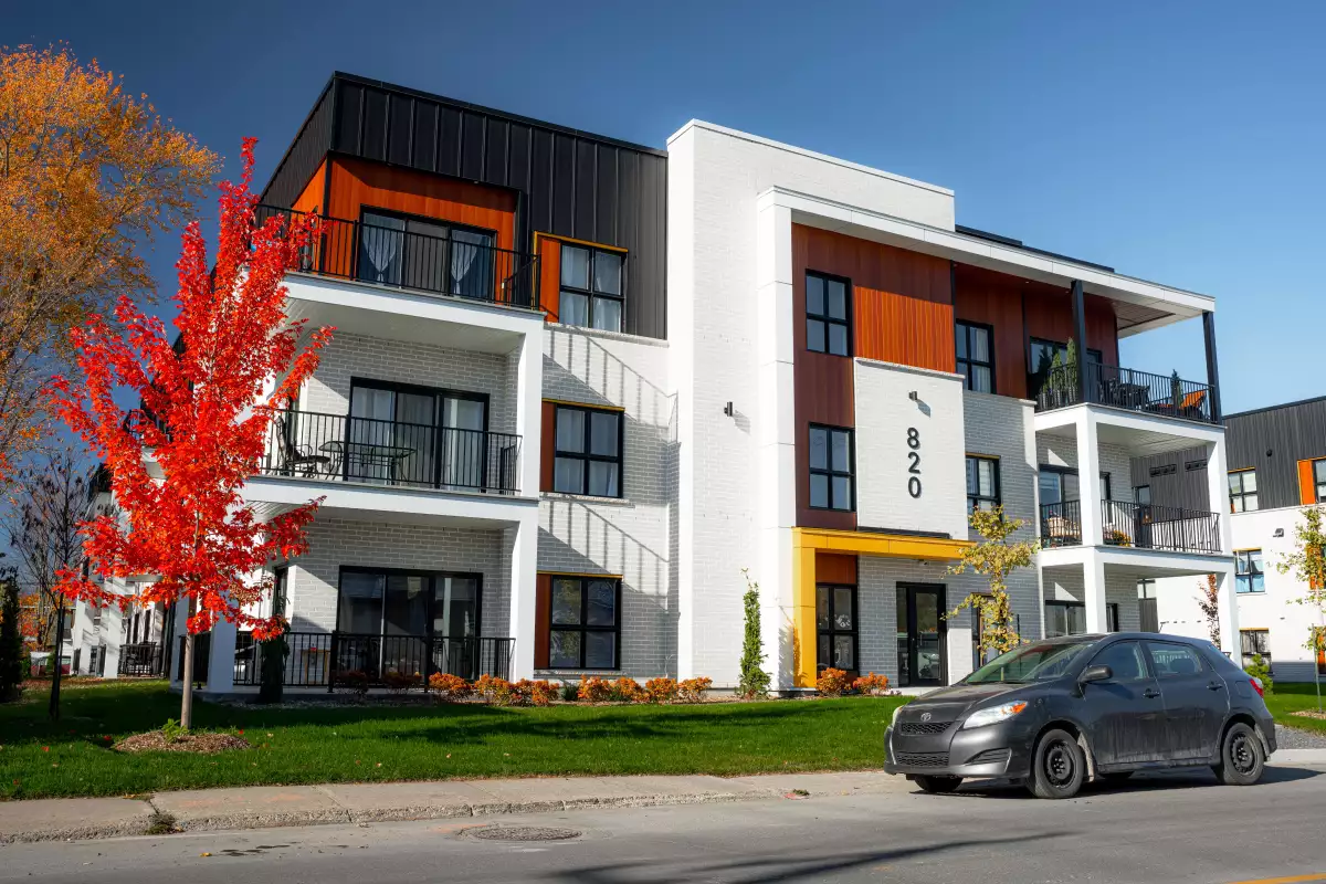 Bâtiment multi-logements avec balcons, revêtement mixte blanc et noir – construction neuve BGC
