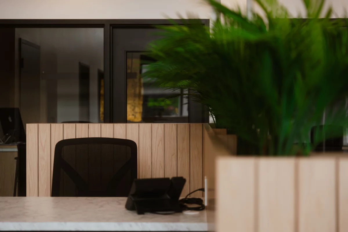 Détail de poste de travail avec cloisons en bois et plantes vertes