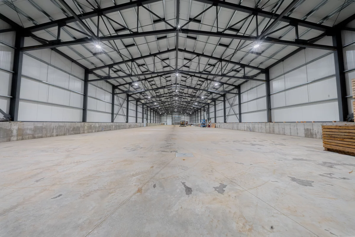 Structure d'acier intérieure avec fermes apparentes et dalle de béton