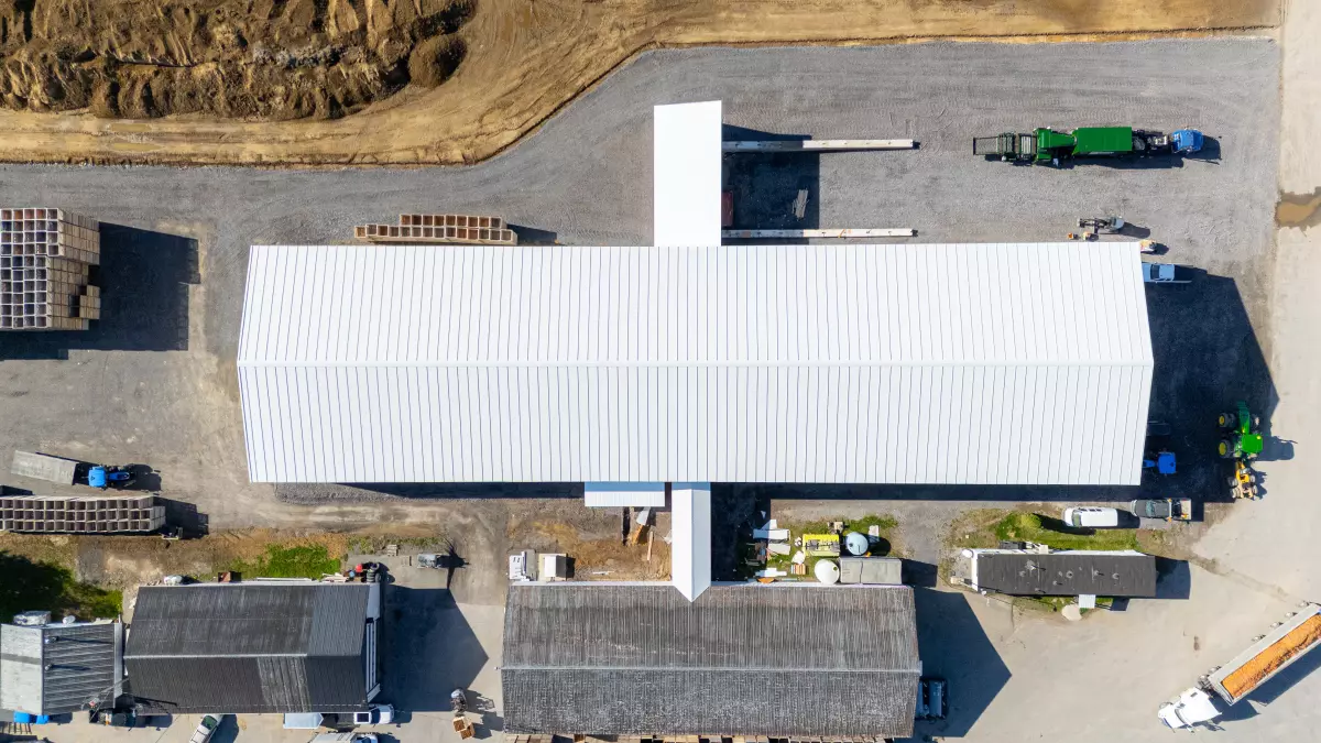 Vue plongeante sur la toiture en tôle blanche du bâtiment agricole