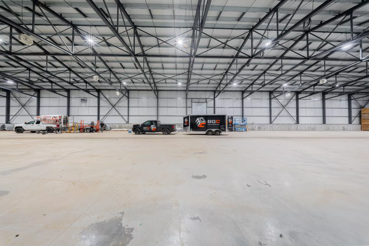 Intérieur du bâtiment avec véhicules BGC et fermes d'acier – construction agricole Joliette