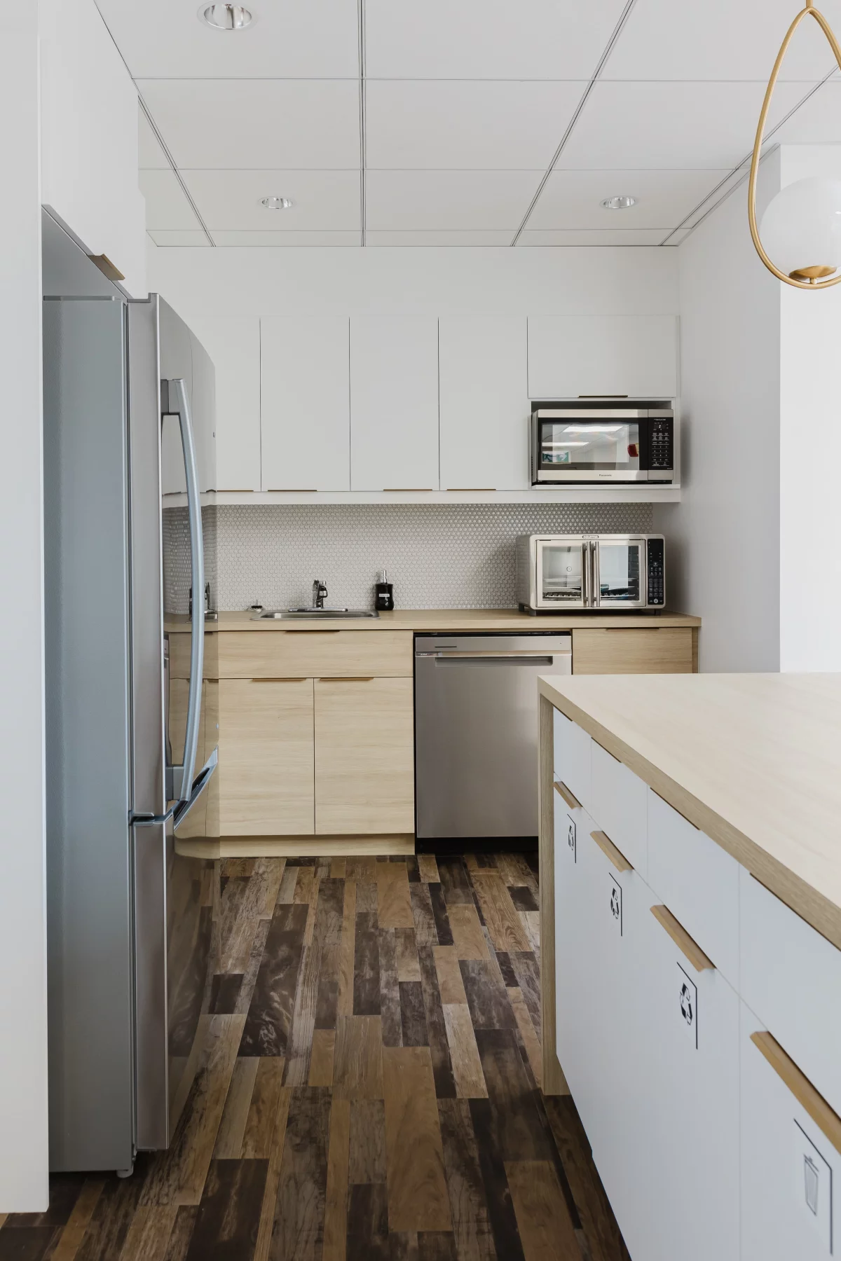 Cuisinette avec armoires blanches et coin café avec tabourets turquoise – aménagement Desjardins BGC