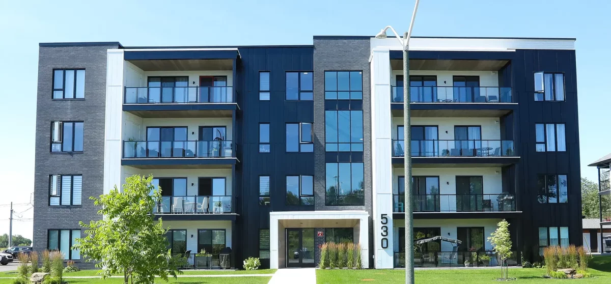 Entrée principale de l'immeuble 530 Munger avec aménagement paysager et balcons vitrés – St-Charles-Borromée